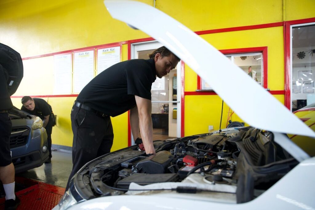Technician inspecting a car after customer noticed a burning smell coming from the engine