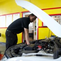 Technician inspecting a car after customer noticed a burning smell coming from the engine